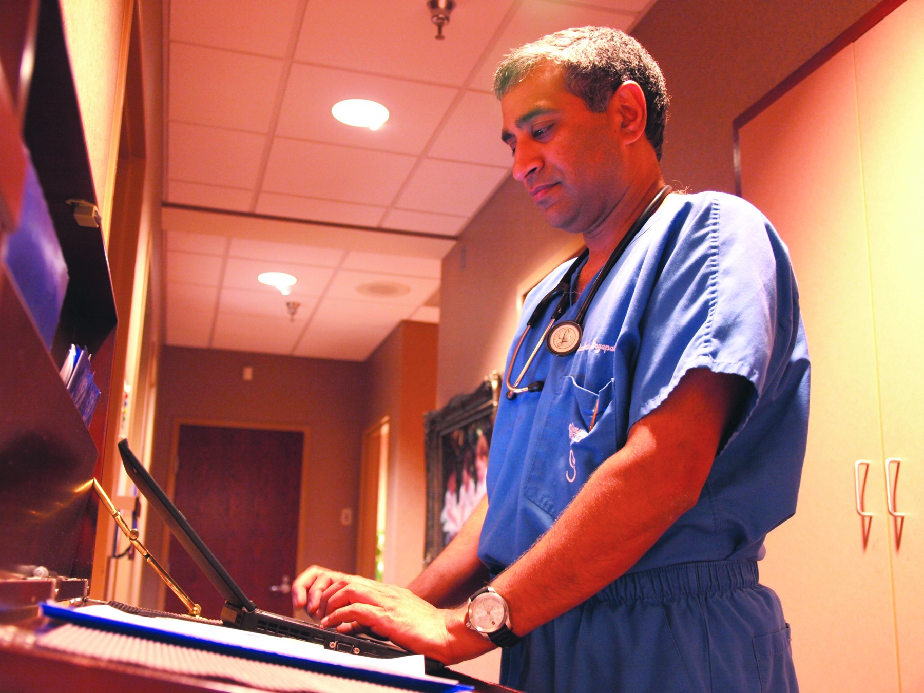 Dr. Madhav Boyapati enters patient information into the clinics electronic medical records.