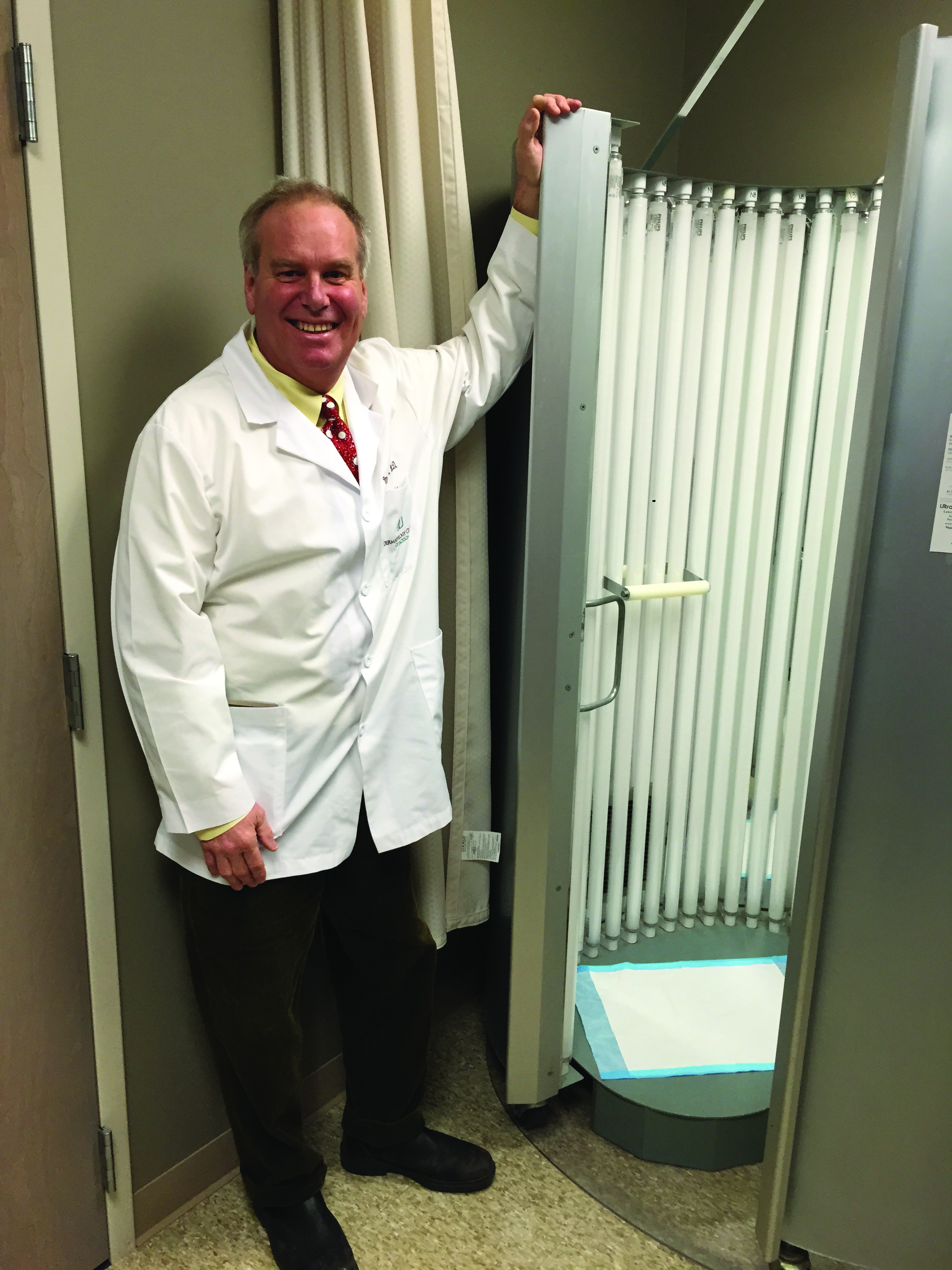 Dr. Mac Jones stands next to the phototherapy box at his clinic.